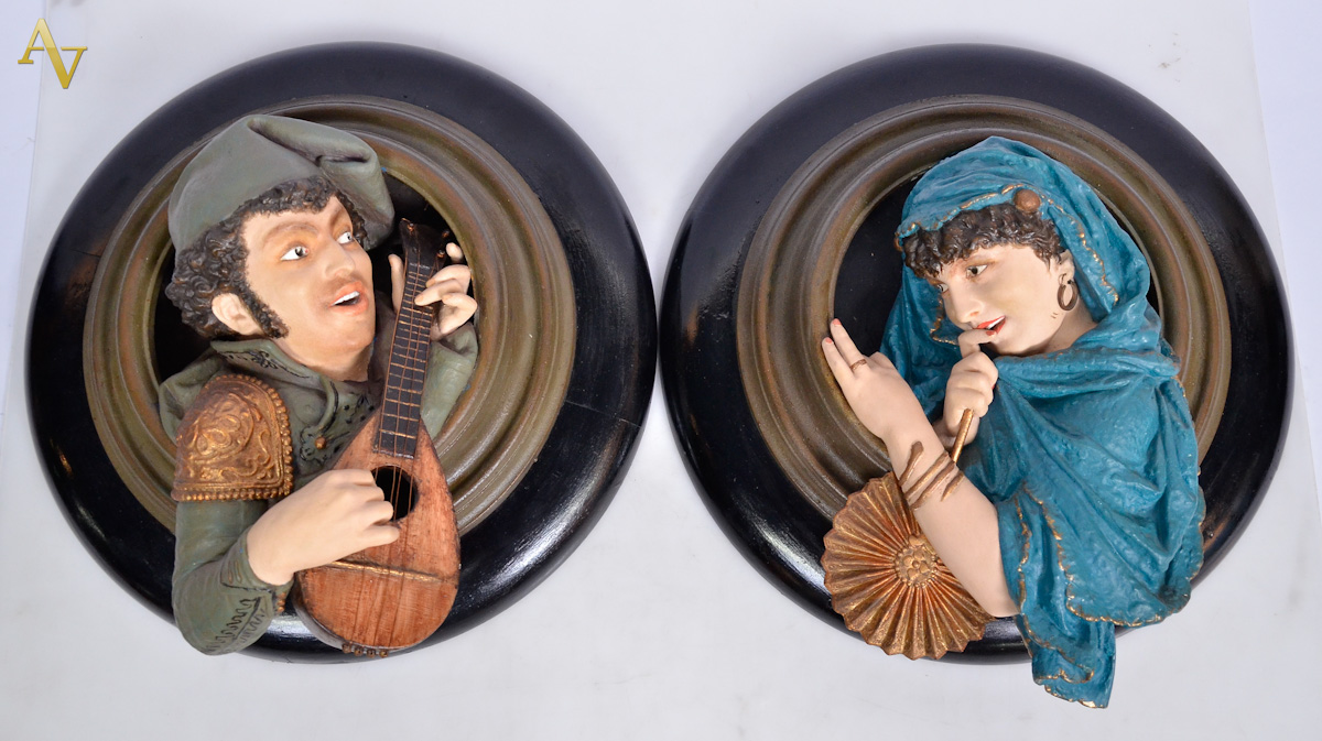 Par de placas de madeira com figuras de metal policromado em relevo...