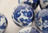 Conjunto com 15 bolas decorativas de porcelana ... - Conjunto com 15 bolas decorativas de porcelana oriental, sendo três verdes florais e 12 menores azuis e brancas.