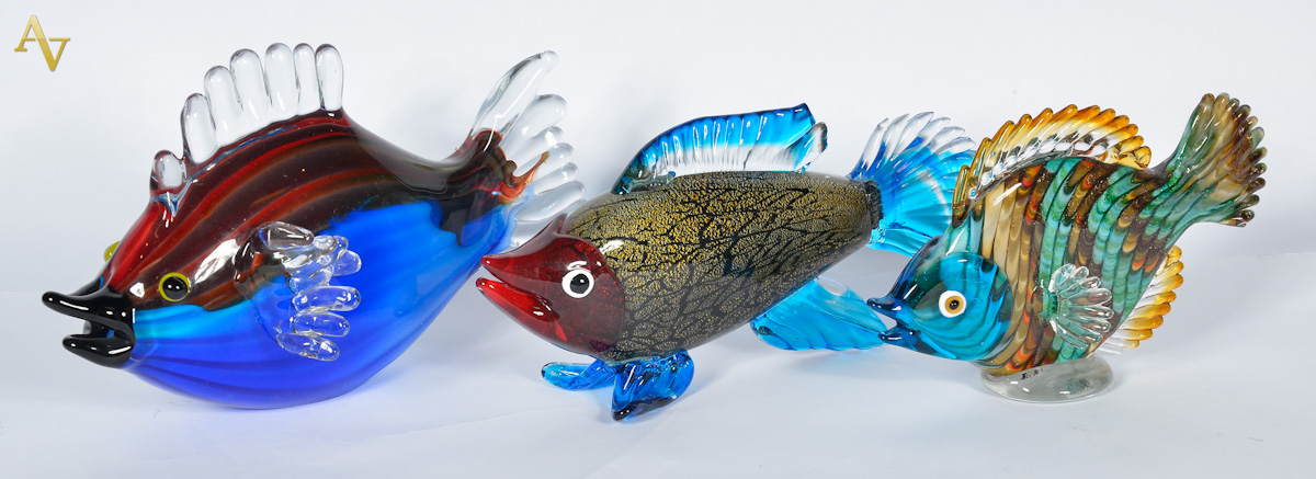 Três peixes de murano com cores variadas; um deles com pequeno...