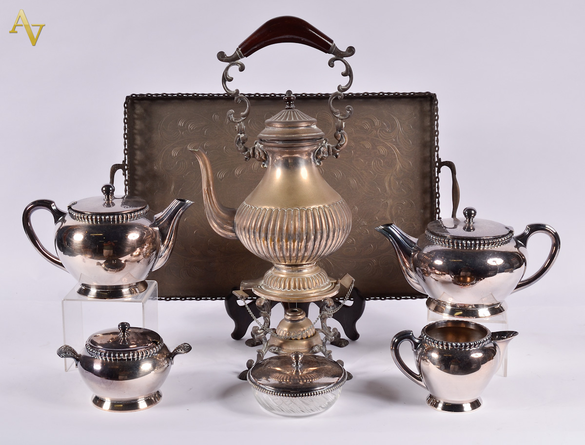 Diversas peças de metal, sendo samovar, bandeja e baixela de chá com...