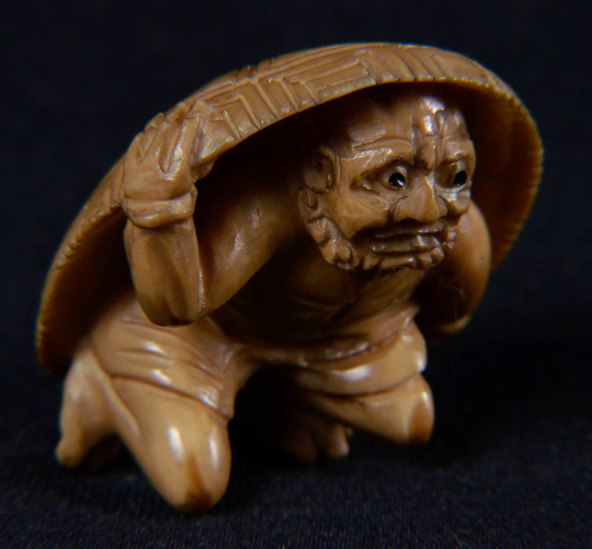 Netsuke de marfim repres.homem com casco de tartaruga.