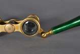 Binóculo feminino com haste articulada de bronz... - Binóculo feminino com haste articulada de bronze e esmalte decorado com flores em policromia sobre fundo verde.