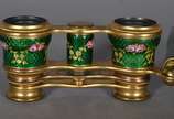 Binóculo feminino com haste articulada de bronz... - Binóculo feminino com haste articulada de bronze e esmalte decorado com flores em policromia sobre fundo verde.