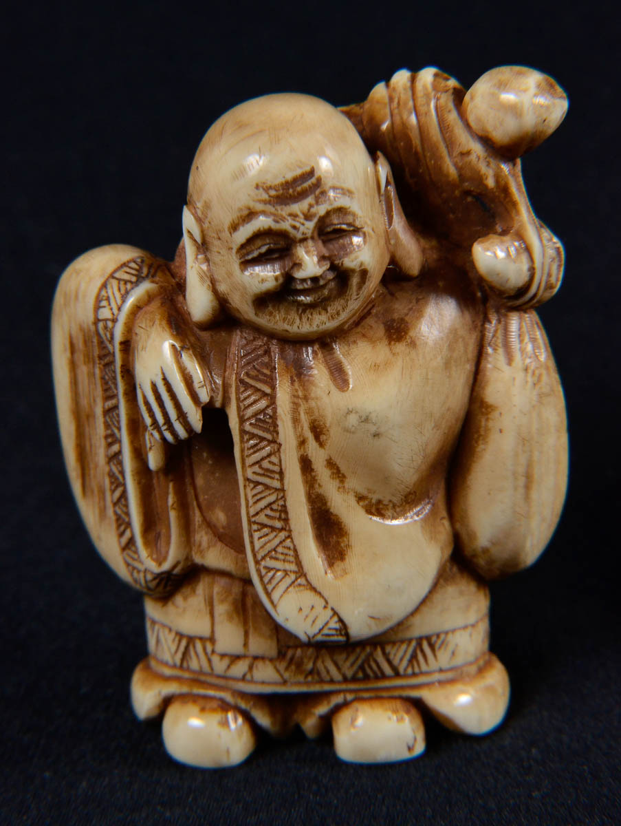 Netsuke de marfim repres.homem com saco nas costas.