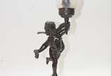 Luminária de metal representando anjo tocheiro,... - Luminária de metal representando anjo tocheiro, manga de vidro. Base oxidada.
