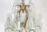 Elegante lustre estilo Versailles de metal dour... - Elegante lustre estilo Versailles de metal dourado com pingentes em placas de cristal lapidado.
