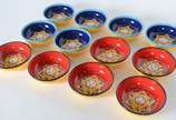 Cerámica Del Río Salado (1969),  - Doze bowls de cerâmica espanhola pintados à mão, nas cores vermelha e azul com estrelas ao fundo.