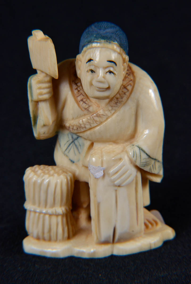 Netsuke de marfim repres.homem com machado.