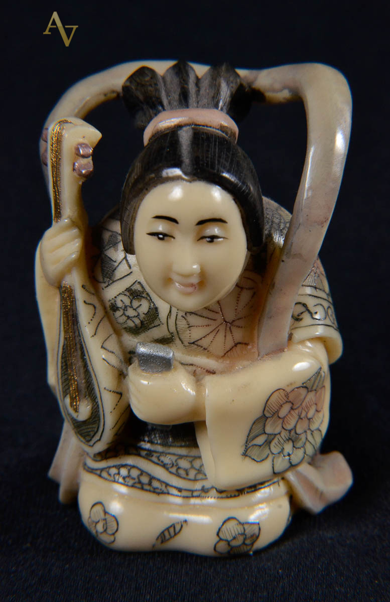 Okimono de marfim assinado repres. mulher com viola, alt. 5 cm.