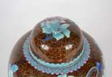 Potiche de cloisonné oriental, decoração floral... - Potiche de cloisonné oriental, decoração floral em policromia sobre fundo marrom, base de madeira.