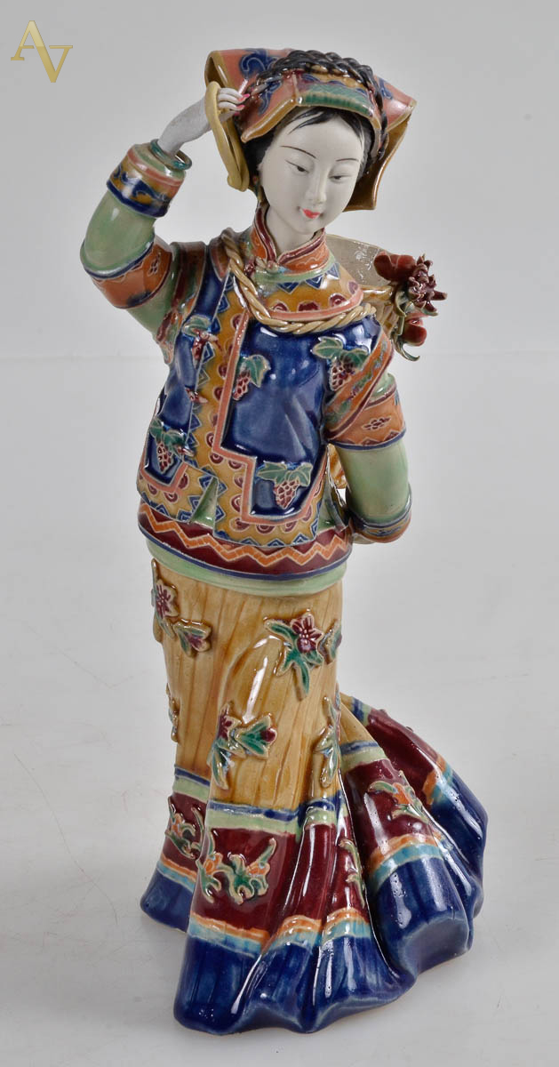 Estatueta em faianca representando menino oriental com cesto. alt 27cm