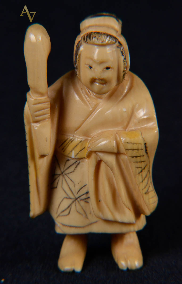 Netsuke de marfim repres figura com cajado.