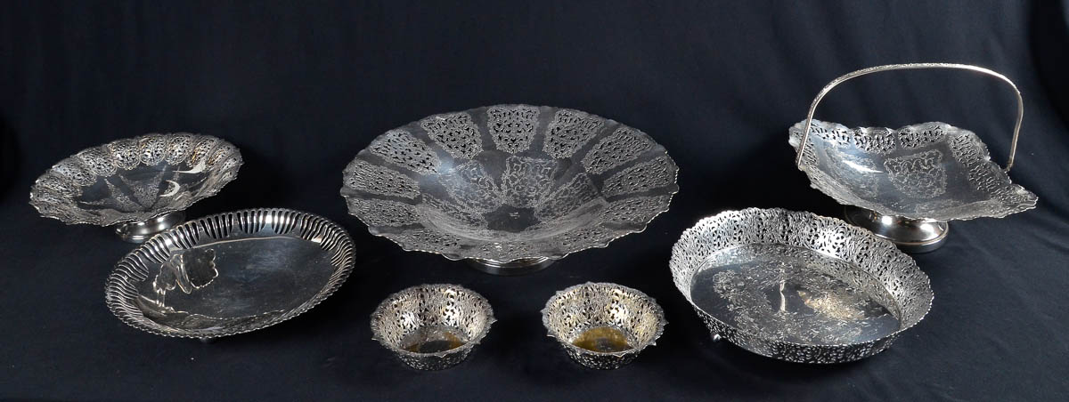 Sete fruteiras de metal prateado, bordas vazadas.