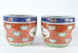 Par de cachepots de porcelana oriental, decorad... - Par de cachepots de porcelana oriental, decorados com aves do paraíso em policromia sobre fundo rouge de fer, bordas superiores em azul cobalto ...