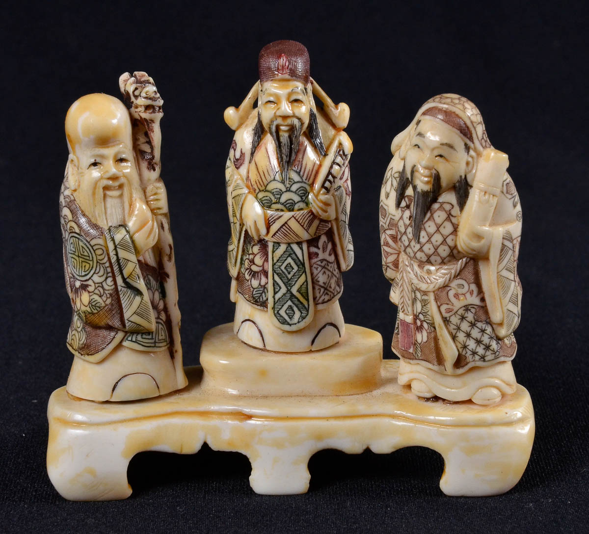Escultura em marfim representando tres filosofos; alt 8cm
