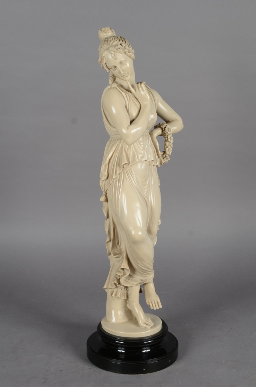 Estatueta de resina representando figura feminina com guirlanda... - foto 1 de 6