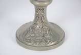 Par de ânforas de metal com anjos, flores e fol... - Par de ânforas de metal com anjos, flores e folhagens em relevo. Uma delas com aplique de figura alada estilizada. Desgastes no metal.