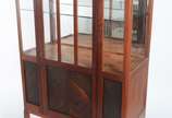 Vitrine de madeira nobre, detalhes entalhados e... - Vitrine de madeira nobre, detalhes entalhados e borda "perolada", porta e laterais de vidro, fundo espelhado, prateleira interna. Desgastes.