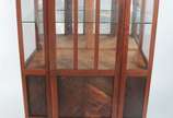 Vitrine de madeira nobre, detalhes entalhados e... - Vitrine de madeira nobre, detalhes entalhados e borda "perolada", porta e laterais de vidro, fundo espelhado, prateleira interna. Desgastes.