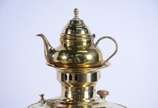 Samovar russo com chaleira de metal dourado, ba... - Samovar russo com chaleira de metal dourado, base redonda. Pegas guarnecidas em madeira torneada com puxadores também em madeira. Apresenta selo...