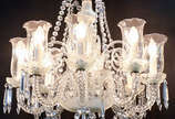 Lustre de cristal com 8 braços, mangas lavradas... - Lustre de cristal com 8 braços, mangas lavradas, contas e pingentes lapidados. Alt.85 cm.