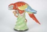 Estatueta de porcelana policromada representand... - Estatueta de porcelana policromada representando papagaio.