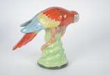 Estatueta de porcelana policromada representand... - Estatueta de porcelana policromada representando papagaio.