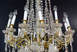 Lustre de bronze e cristal com 12 braços superi... - Lustre de bronze e cristal com 12 braços superiores e 6 inferiores com mangas foscas , pingentes e placas lapidados.
