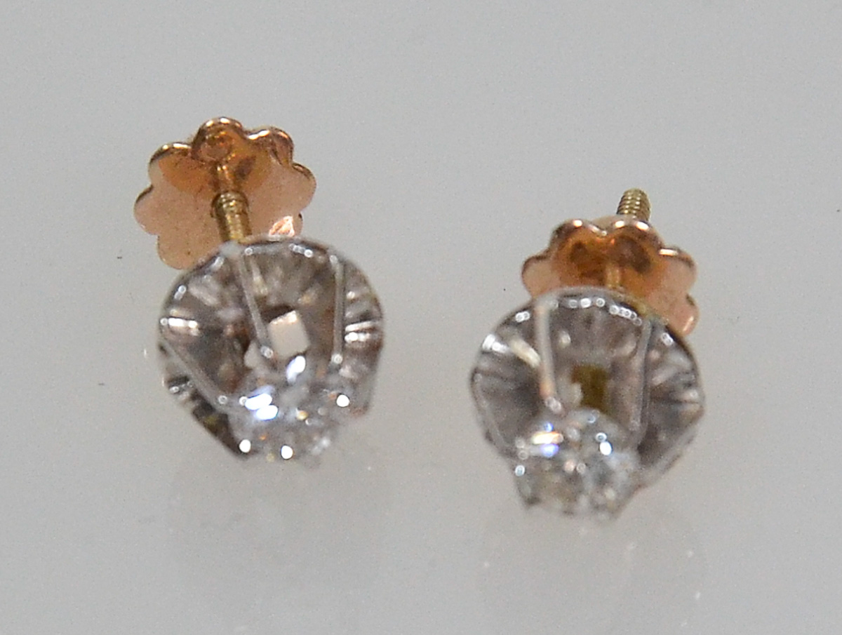 Par de brincos de ouro 18 k com 2 brilhantes, peso 1,8 g.