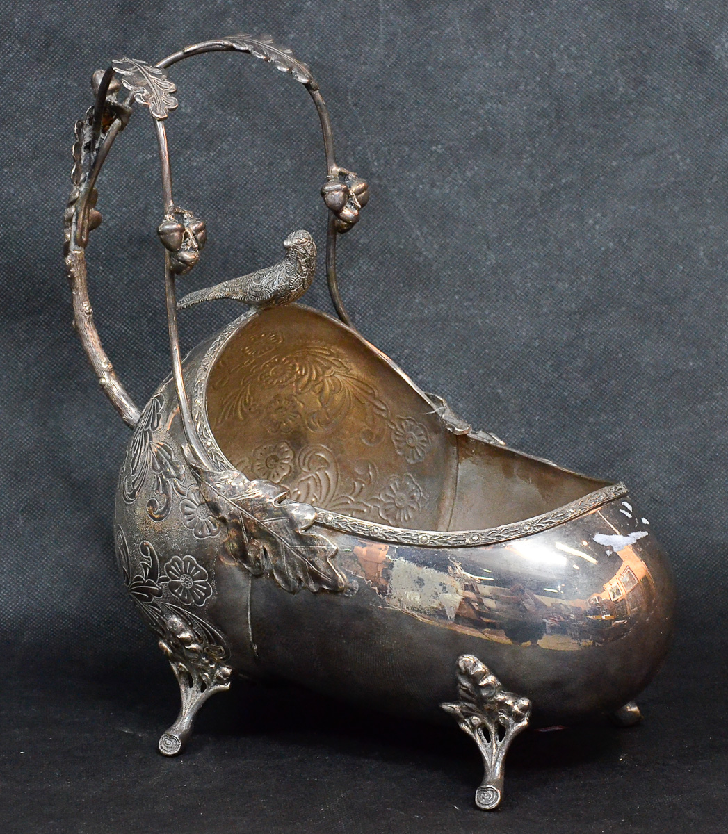 Porta vinho de metal prateado com flores em relevo, alt.28 cm.