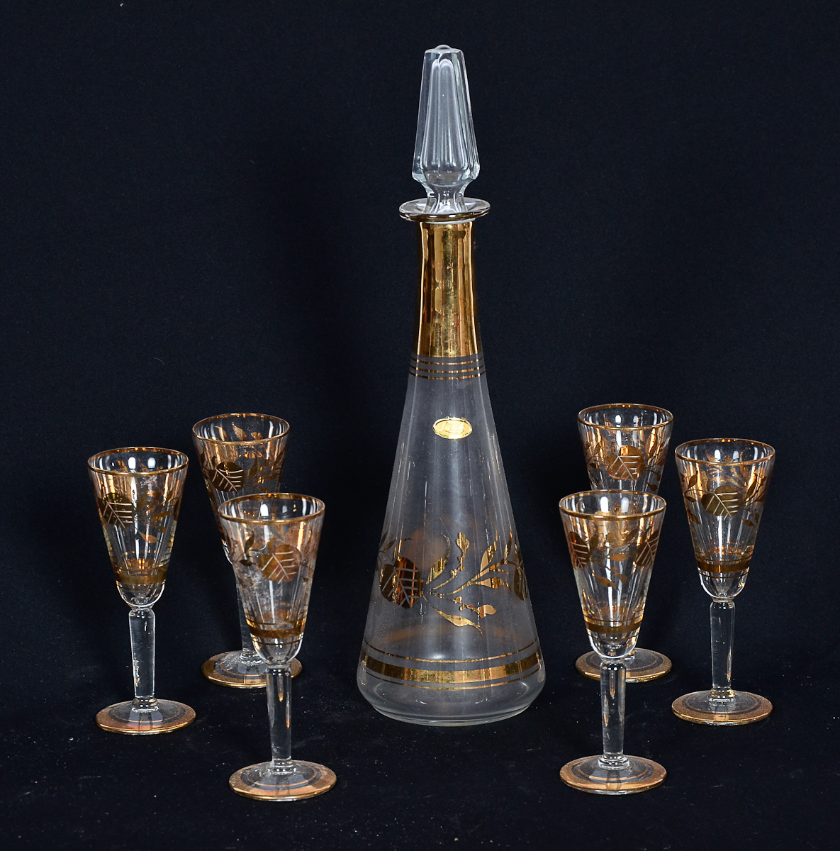 Licoreira com 6 cálices de cristal decorado com flores douradas.
