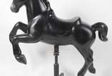 Grande escultura na forma de Cavalo de carrosse... - Grande escultura na forma de Cavalo de carrossel em fibra preta, sobre rodízios.