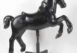 Grande escultura na forma de Cavalo de carrosse... - Grande escultura na forma de Cavalo de carrossel em fibra preta, sobre rodízios.