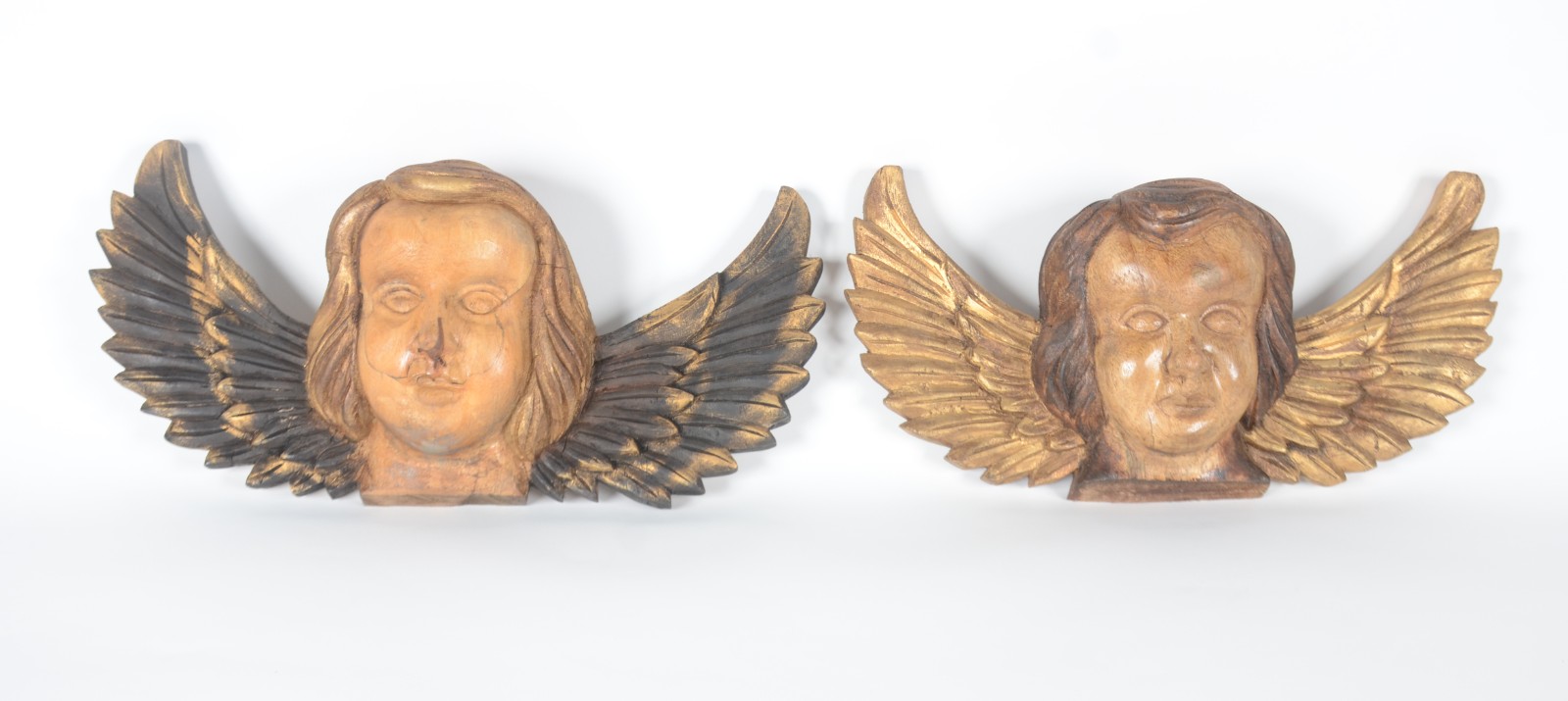Par de cabeças de anjos de madeira entalhada e realces dourados. - foto 1 de 4