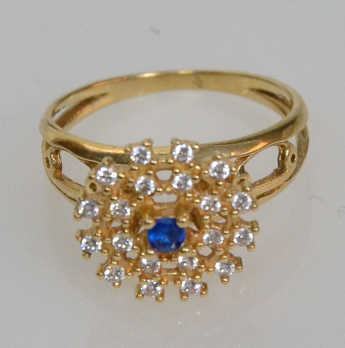 Anel de ouro 18 k com safira central e 20 brilhantes, peso 4,1 g.