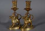 Par de castiçais de bronze com figuras infantis... - Par de castiçais de bronze com figuras infantis montando animais alados. Marcas na base CHL.