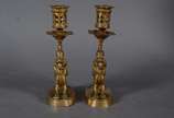 Par de castiçais de bronze com figuras infantis... - Par de castiçais de bronze com figuras infantis montando animais alados. Marcas na base CHL.