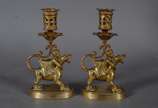 Par de castiçais de bronze com figuras infantis... - Par de castiçais de bronze com figuras infantis montando animais alados. Marcas na base CHL.