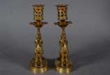 Par de castiçais de bronze com figuras infantis... - Par de castiçais de bronze com figuras infantis montando animais alados. Marcas na base CHL.