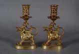 Par de castiçais de bronze com figuras infantis... - Par de castiçais de bronze com figuras infantis montando animais alados. Marcas na base CHL.