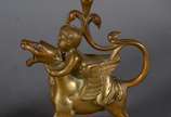 Par de castiçais de bronze com figuras infantis... - Par de castiçais de bronze com figuras infantis montando animais alados. Marcas na base CHL.