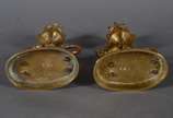 Par de castiçais de bronze com figuras infantis... - Par de castiçais de bronze com figuras infantis montando animais alados. Marcas na base CHL.
