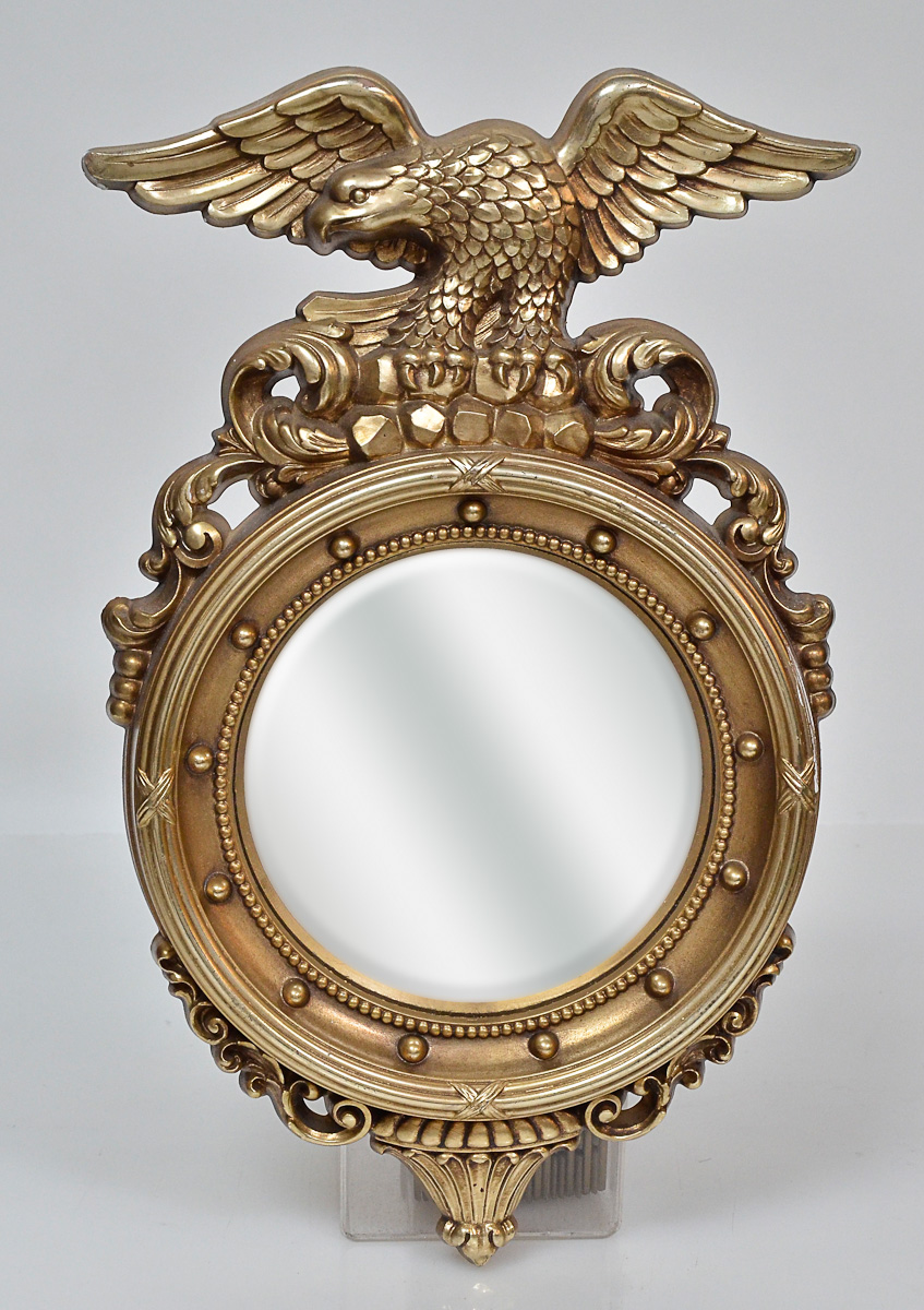 Espelho esférico encimado por figura de áhuia dourada, alt. 40 cm.