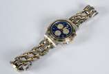 Bulova (1875),  - Relógio masculino com cronógrafo, modelo marina Star, calendário, pulseira e caixa em aço com detalhes dourados, fundo azul. (Por motivos de segurança