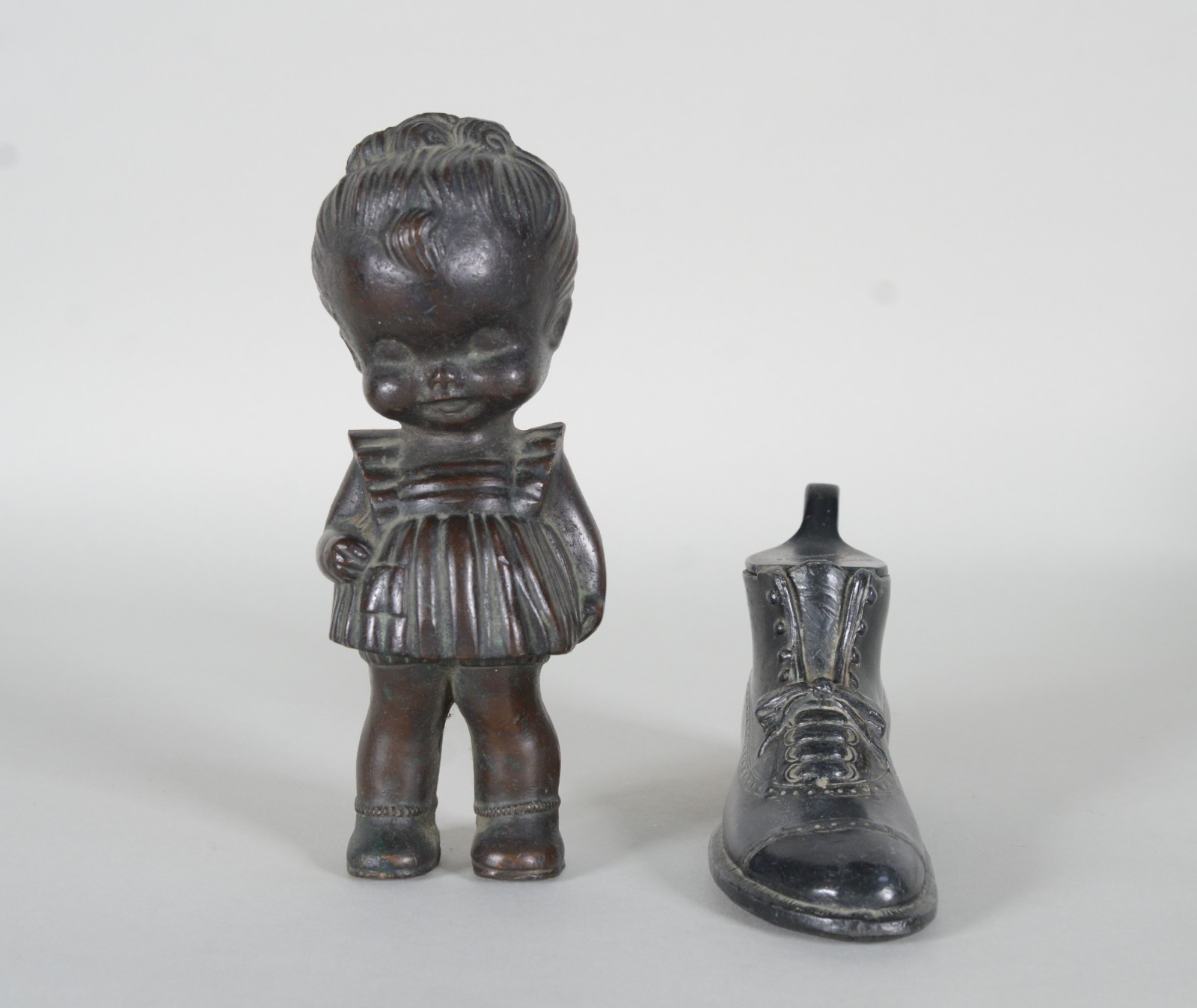 Duas esculturas, sendo: sapato de metal e menina de bronze. - foto 2 de 10