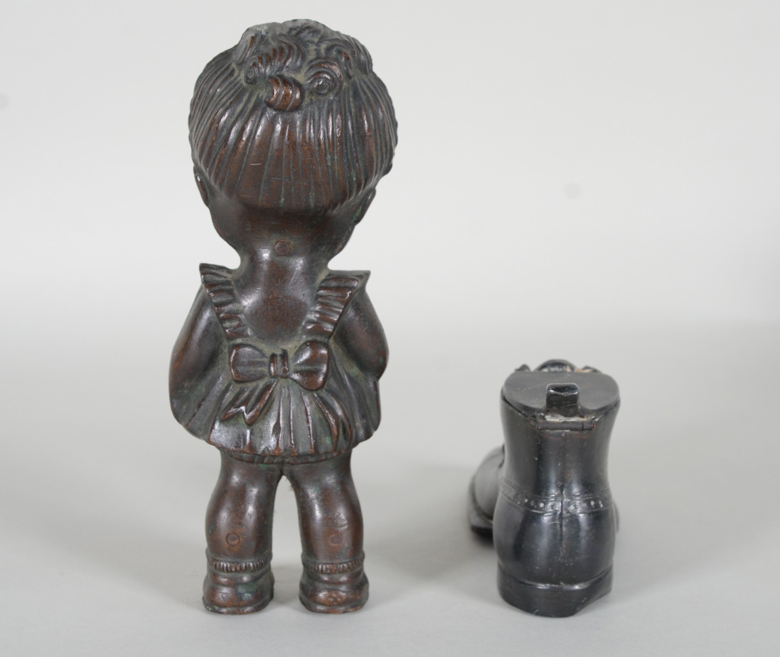 Duas esculturas, sendo: sapato de metal e menina de bronze. - foto 5 de 10