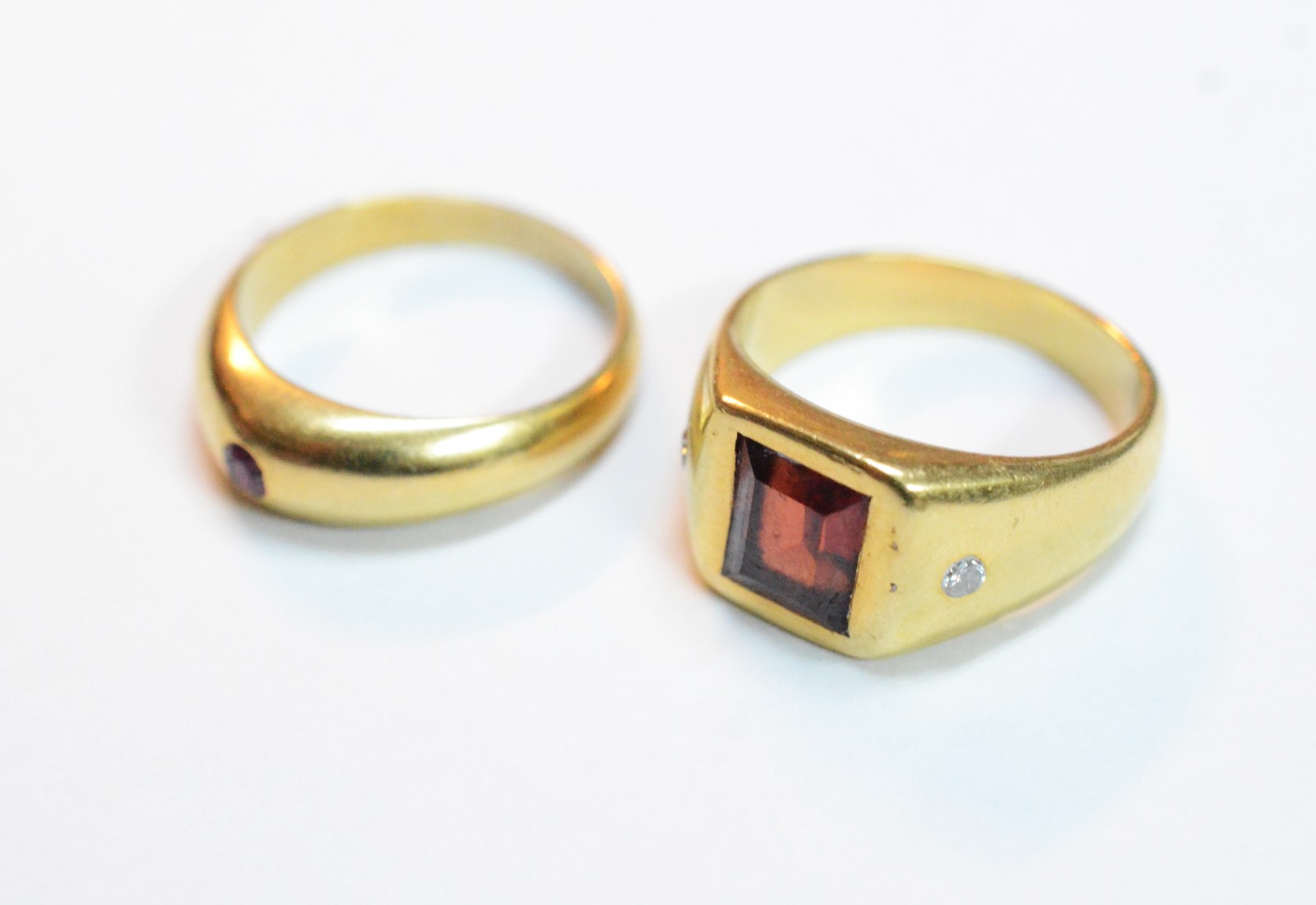 Dois anéis de ouro 18 k, sendo um com pedra vermelha e pequenos... - foto 1 de 7