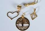Quatro pendentes de ouro, contraste 750 sendo: ... - Quatro pendentes de ouro, contraste 750 sendo: figa, coração com vazados, árvore da fortuna e diamante.  (Por motivos de segurança a peça não se...