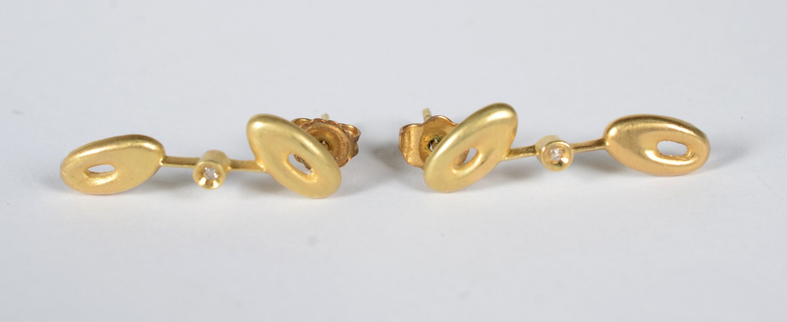 Par de brincos de ouro 18 k com vazados com 1 diamante no centro em... - foto 1 de 6