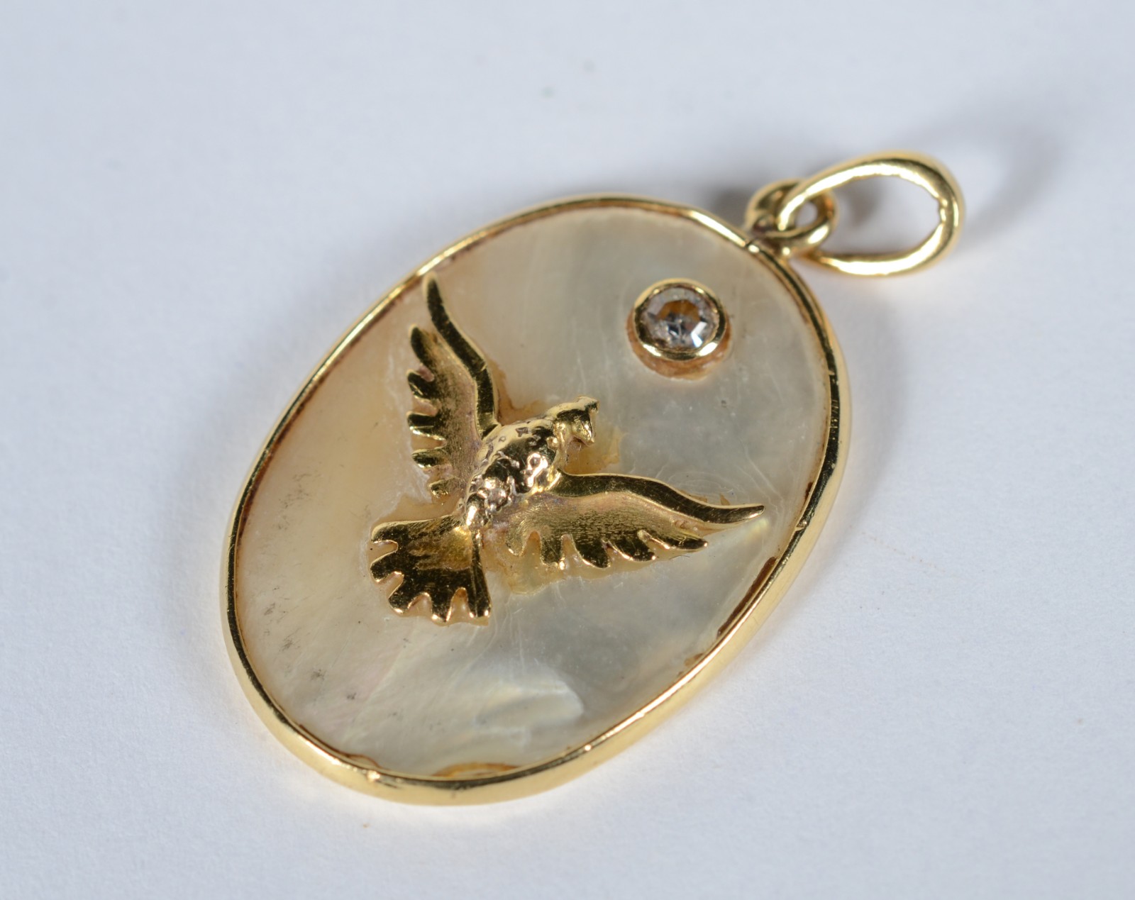 Pendente de ouro 18 k, feitio oval com madre perola com pomba da Paz... - foto 1 de 4